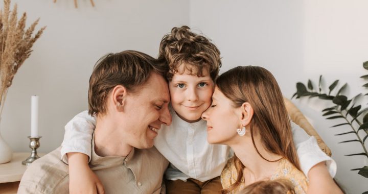 A joyful family moment with parents and their son embracing indoors.