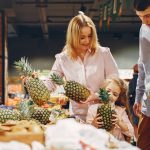 A happy family shopping for fresh pineapples together in a supermarket.